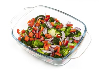 beyaz zemin üzerinde bir cam tabakta sebze salatası. İzole