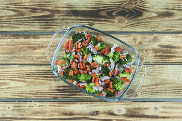 Groente salade in een glazen schaal op een houten achtergrond — Stockfoto
