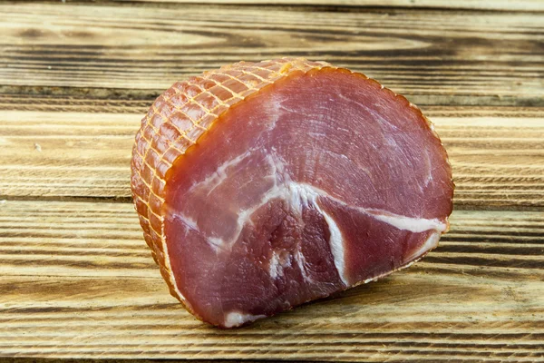 Smoked ham on a wooden background — Stock Photo, Image