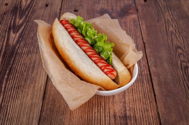 Ahşap arka planda sosisli sandviç. Portföydeki başka bir açıdan görüntüle.