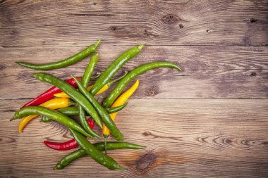 Ahşap arka planda küçük biberler. Portföydeki başka bir açıdan görüntüle.