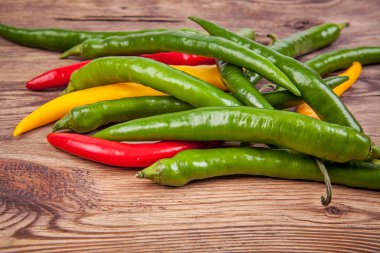 Ahşap arka planda küçük biberler. Portföydeki başka bir açıdan görüntüle.