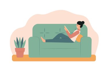 Kanepede kitap okuyan genç bir kadın. Evde elinde kitapla oturan mutlu kız.