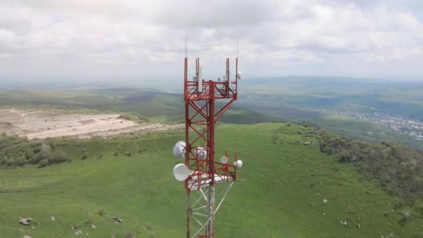 Voo aéreo em torno da torre de telecomunicações instalada no topo da colina — Vídeo de Stock