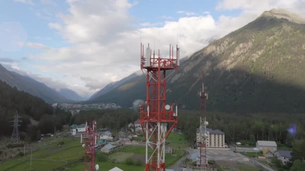 Mobiele telecommunicatietoren in het kleine stadje tussen bergen — Stockvideo