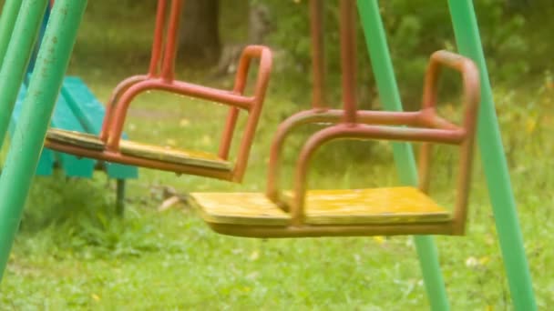 Dois balanços no parque infantil vazio como pêndulo, close-up — Vídeo de Stock