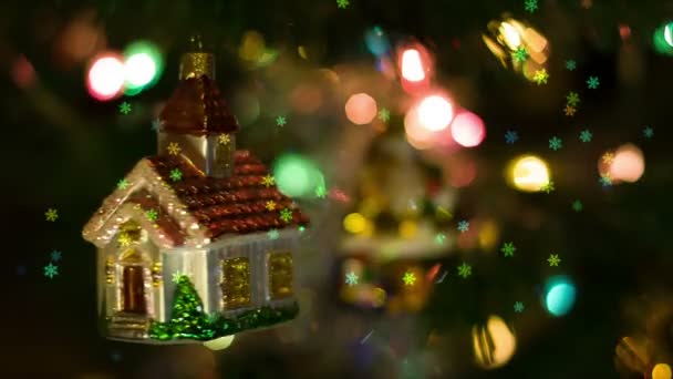 Домашняя игрушка вращается на новогоднем дереве и падают снежинки — стоковое видео
