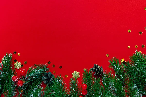 Kırmızı bir zemin üzerinde dallar ve koniler metin için yer var. Noel ve yeni yıl arkaplanı