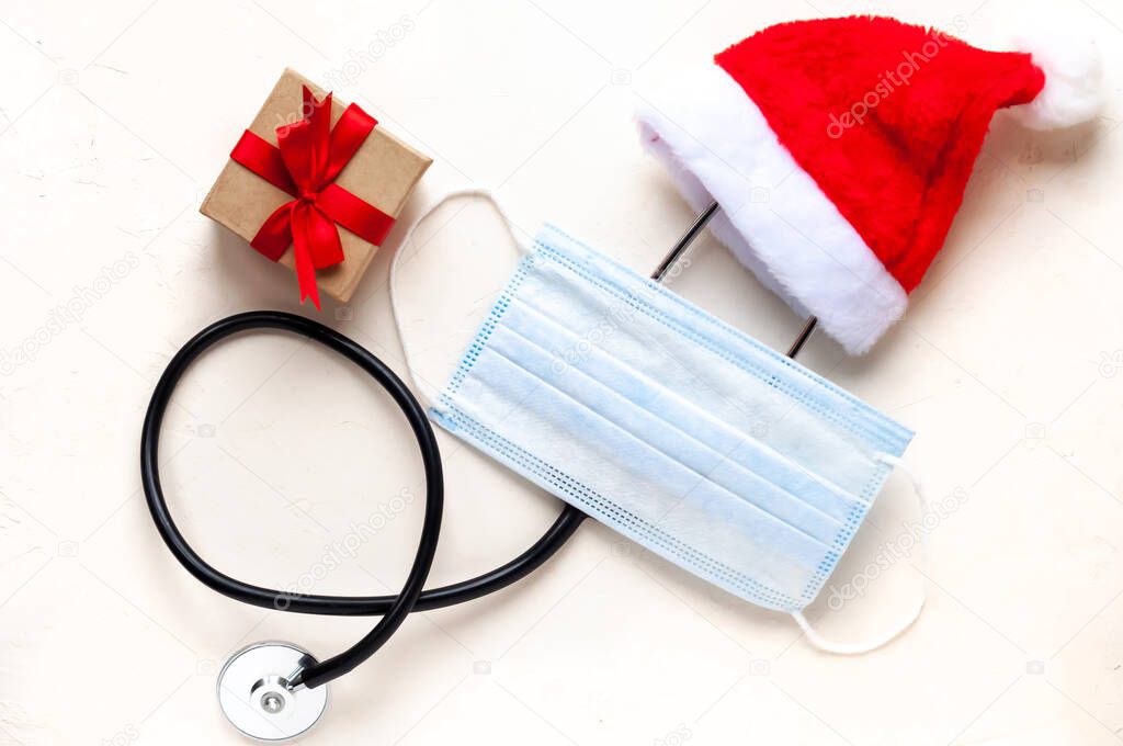 christmas medical flatlay. Medical stethoscope, neurological hammer, gift, Christmas decorations on a white background. Copyspace