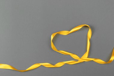 Gri arkaplanda sarı saten kurdele. İz rengi 2021..