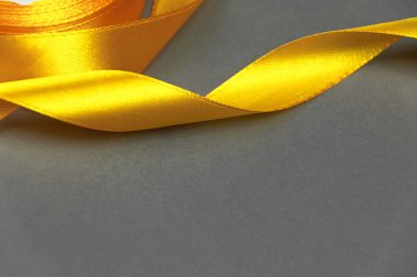 Gri arkaplanda sarı saten kurdele. İz rengi 2021..