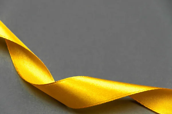 Yellow satin ribbon on a gray background.Track colors 2021.