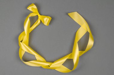 Gri arkaplanda sarı saten kurdele. Renkler 2021