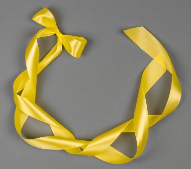 Gri arkaplanda sarı saten kurdele. Renkler 2021