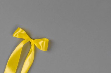 Gri arkaplanda sarı saten kurdele. Renkler 2021