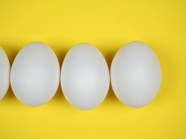 Sarı arka planda beyaz yumurtalar