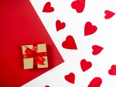 Kırmızı ve beyaz arkaplanda hediyeler ve kırmızı kalpler. Sevgililer Günü.