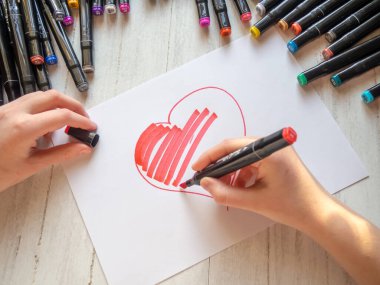 Eller işaretli kırmızı bir kalp çizer