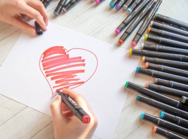 Eller işaretli kırmızı bir kalp çizer