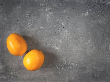 Gri beton arka planda iki limon.