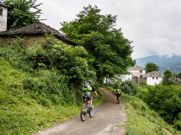 Mountain bikers in an old mountain village. Bulgaria. — Stockfoto