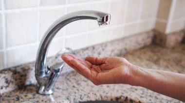 Su sıkıntısı. Çeşme ve orta yaşlı kadınların elleri. Küresel ısınma iklim değişikliğine yol açtı. Kuraklık kavramı.