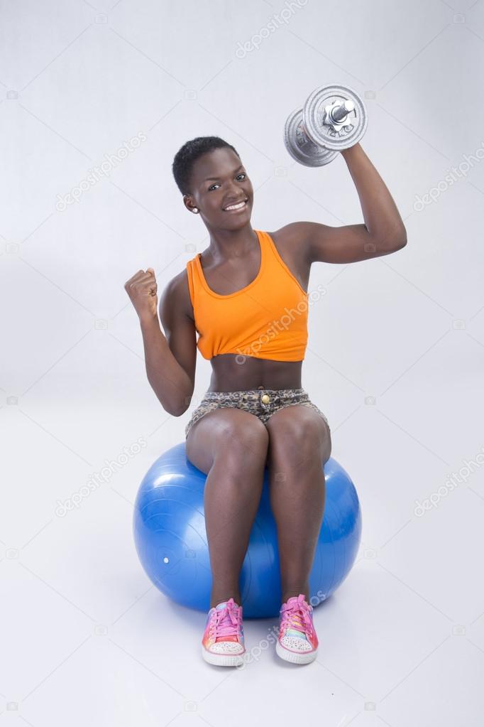 woman with dumbbell sit on ball