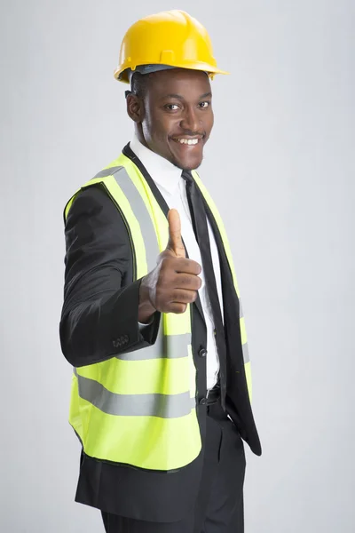 Молодий усміхнений інженер з шоломом і уніформою — стокове фото