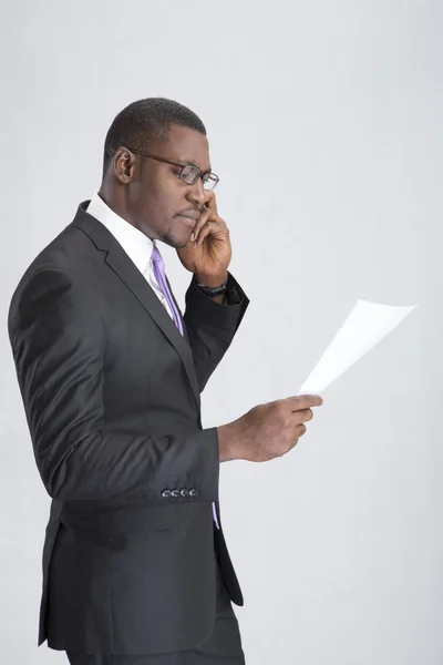 Jovem empresário falando celular com documento — Fotografia de Stock