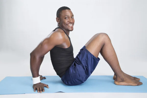 Young sportsman does exercices on carpet — Stock Photo, Image