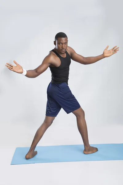 Young sportsman does exercices on carpet — Stock Photo, Image