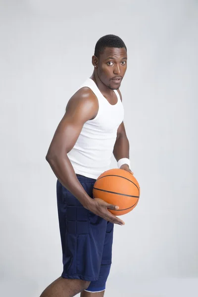 Jeune sportif posant avec ballon de basket — Photo