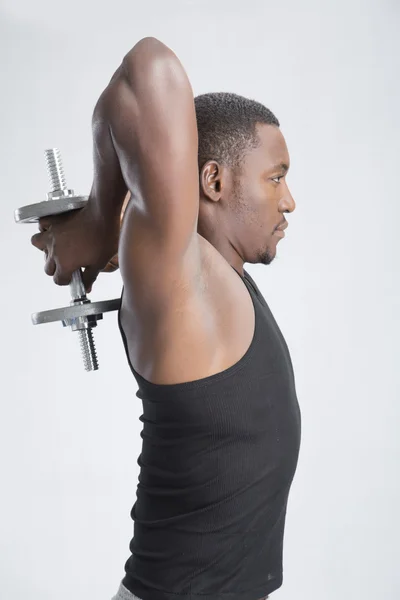 Joven deportista levantando mancuerna — Foto de Stock