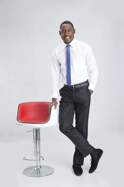 Young businessman near red armchair — Stock Photo, Image