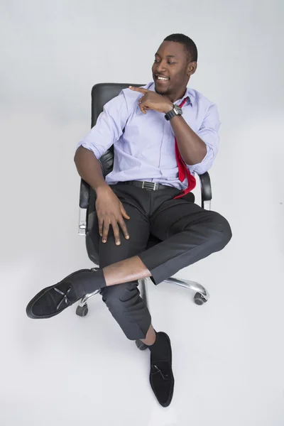 Jovem homem de negócios feliz sentado em poltrona — Fotografia de Stock