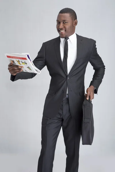Jonge lachende zakenman met krant — Stockfoto