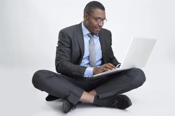 Jovem empresário sentado com laptop — Fotografia de Stock