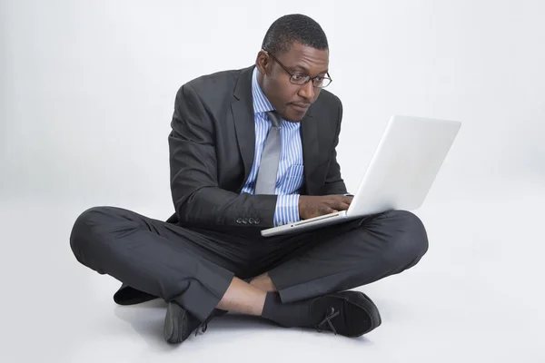 Jovem empresário sentado com laptop — Fotografia de Stock