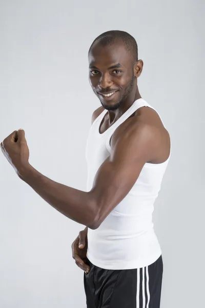 Young man shows muscles — Stock Photo, Image