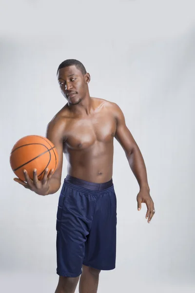 Deportista posando con pelota de baloncesto Imágenes de stock libres de derechos