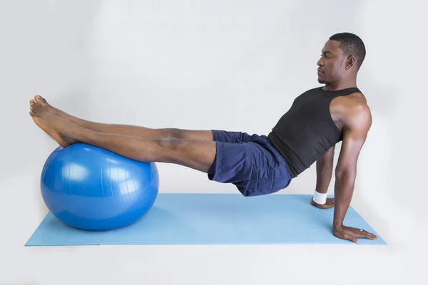 Joven deportista hace fitness con globo y en la alfombra Fotos de stock libres de derechos