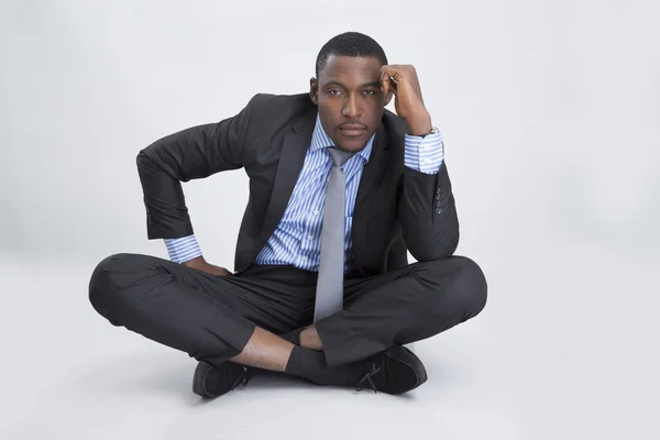Young serious businessman sitting on floor Stock Picture