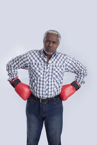 Alter Mann mit Boxhandschuhen auf grau — Stockfoto