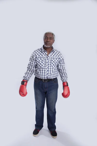 Hombre viejo con guantes de boxeo en gris —  Fotos de Stock