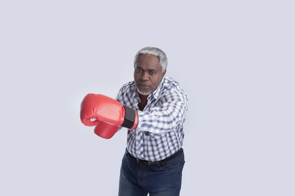 Hombre viejo con guantes de boxeo en gris — Foto de Stock