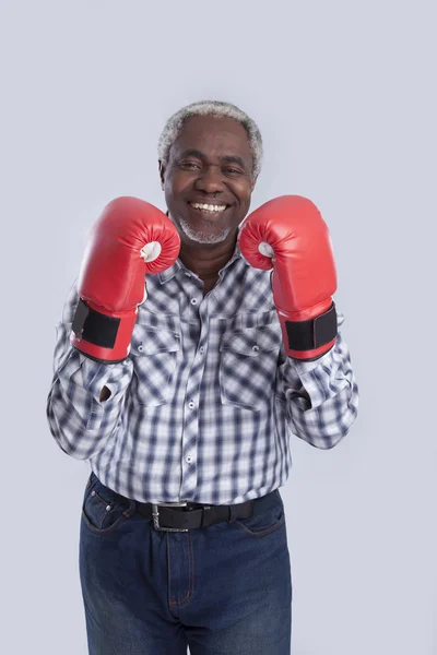 Hombre viejo sonriendo con guantes de boxeo — Foto de Stock