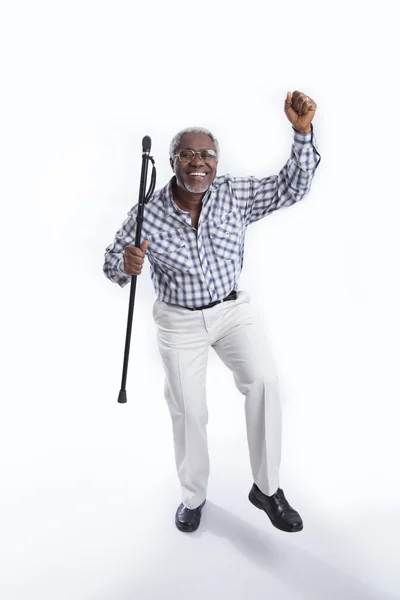 Aged man dances with cane and smiles — Stock Photo, Image