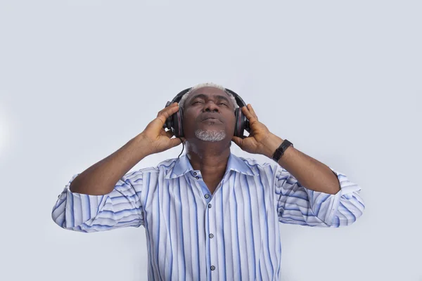Starszy mężczyzna z słuchawki słucha muzyki — Zdjęcie stockowe