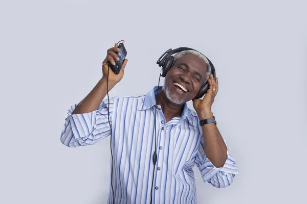 Aged man with headphones listens to the music — Stock Photo, Image