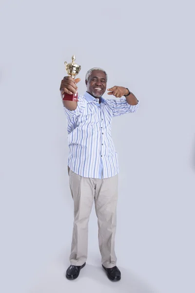 У віці чоловік тримає кубок переможців — стокове фото